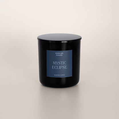 Mystic Eclipse black glass candle with blue-grey label by POSH ME, PLEASE., lid on, light background
