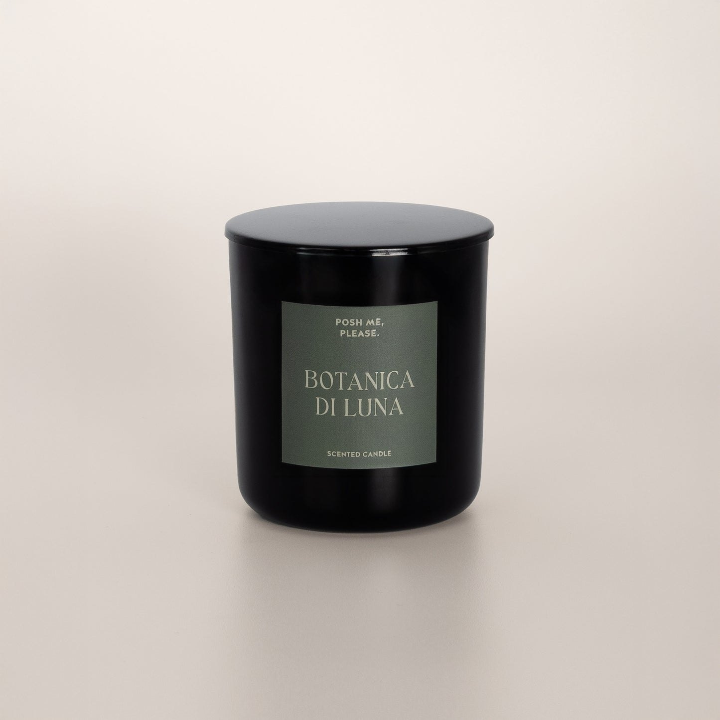 Botanica di Luna black glass candle with green label by POSH ME, PLEASE., lid on, light background
