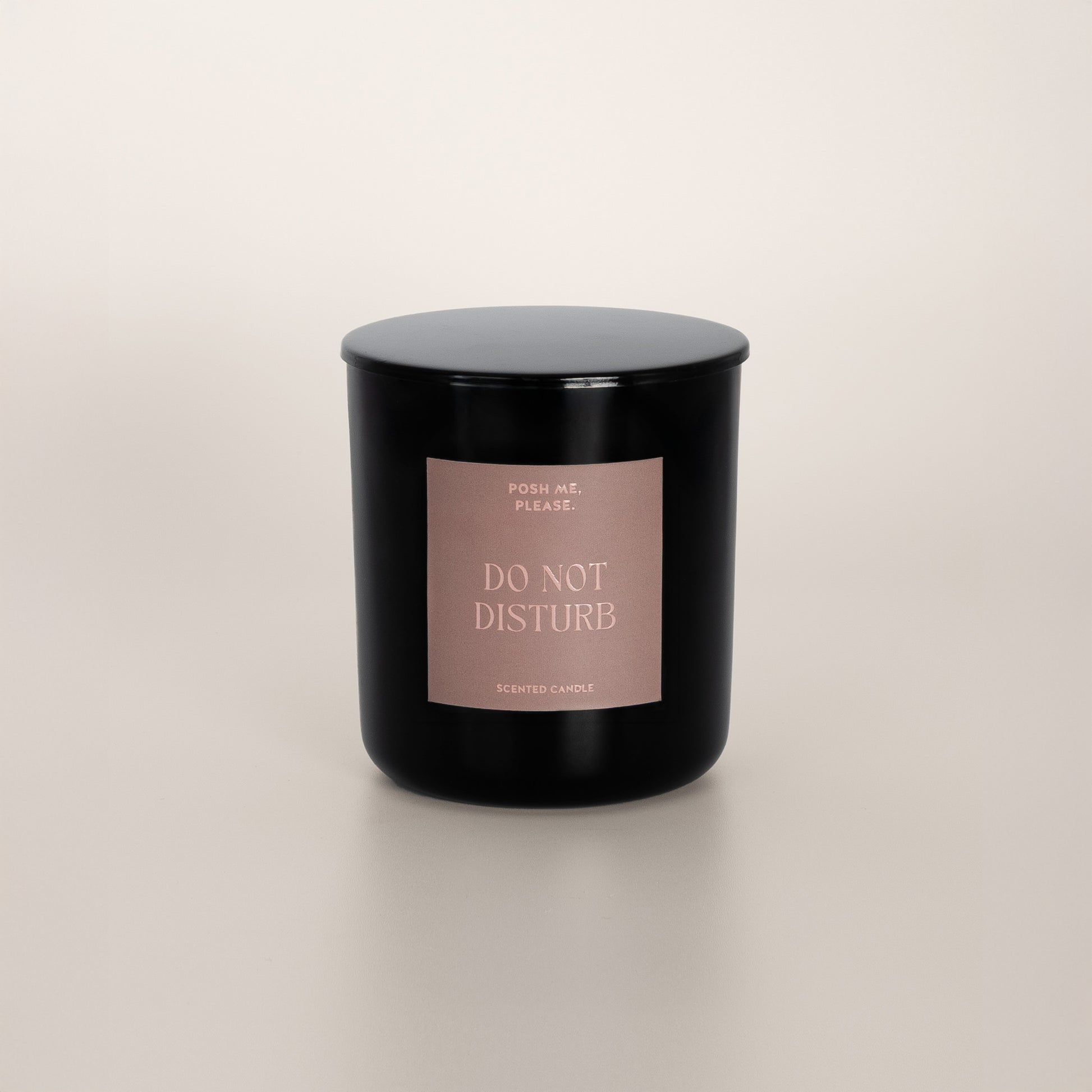 Do Not Disturb black glass candle with blush rose label by POSH ME, PLEASE., lid on, light background
