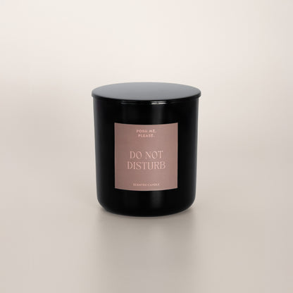 Do Not Disturb black glass candle with blush rose label by POSH ME, PLEASE., lid on, light background
