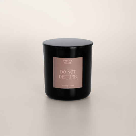 Do Not Disturb black glass candle with blush rose label by POSH ME, PLEASE., lid on, light background