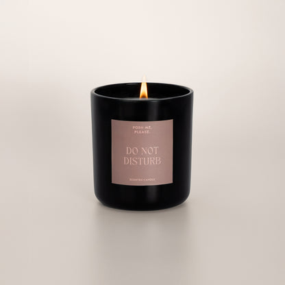 Lit Do Not Disturb candle with flame, citrus neroli scent, neutral background