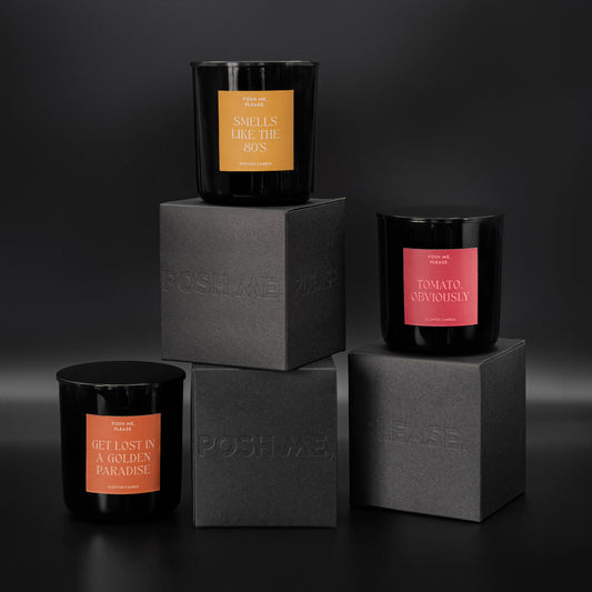 Smells Like The 80s, Tomato Obviously and Get Lost in a Golden Paradise candles stacked on embossed POSH ME, PLEASE. black blocks, dark background