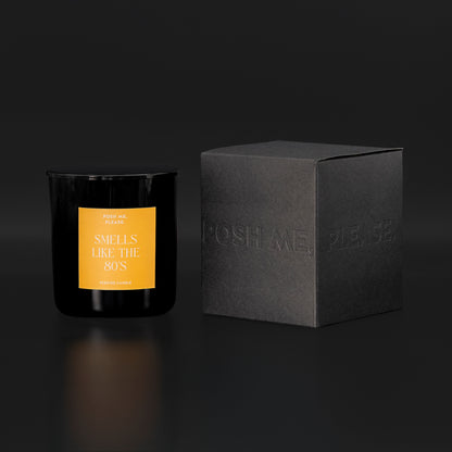 Smells Like The 80s candle beside black embossed POSH ME, PLEASE. gift box, dark background