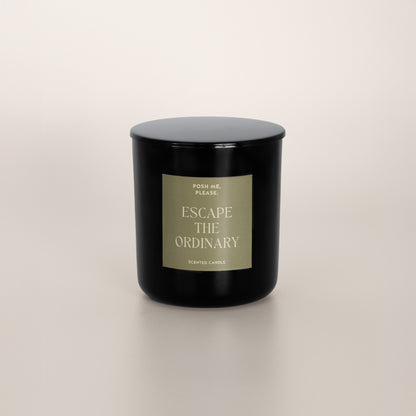 Escape the Ordinary black glass candle with olive green label by POSH ME,
PLEASE., lid on, light background