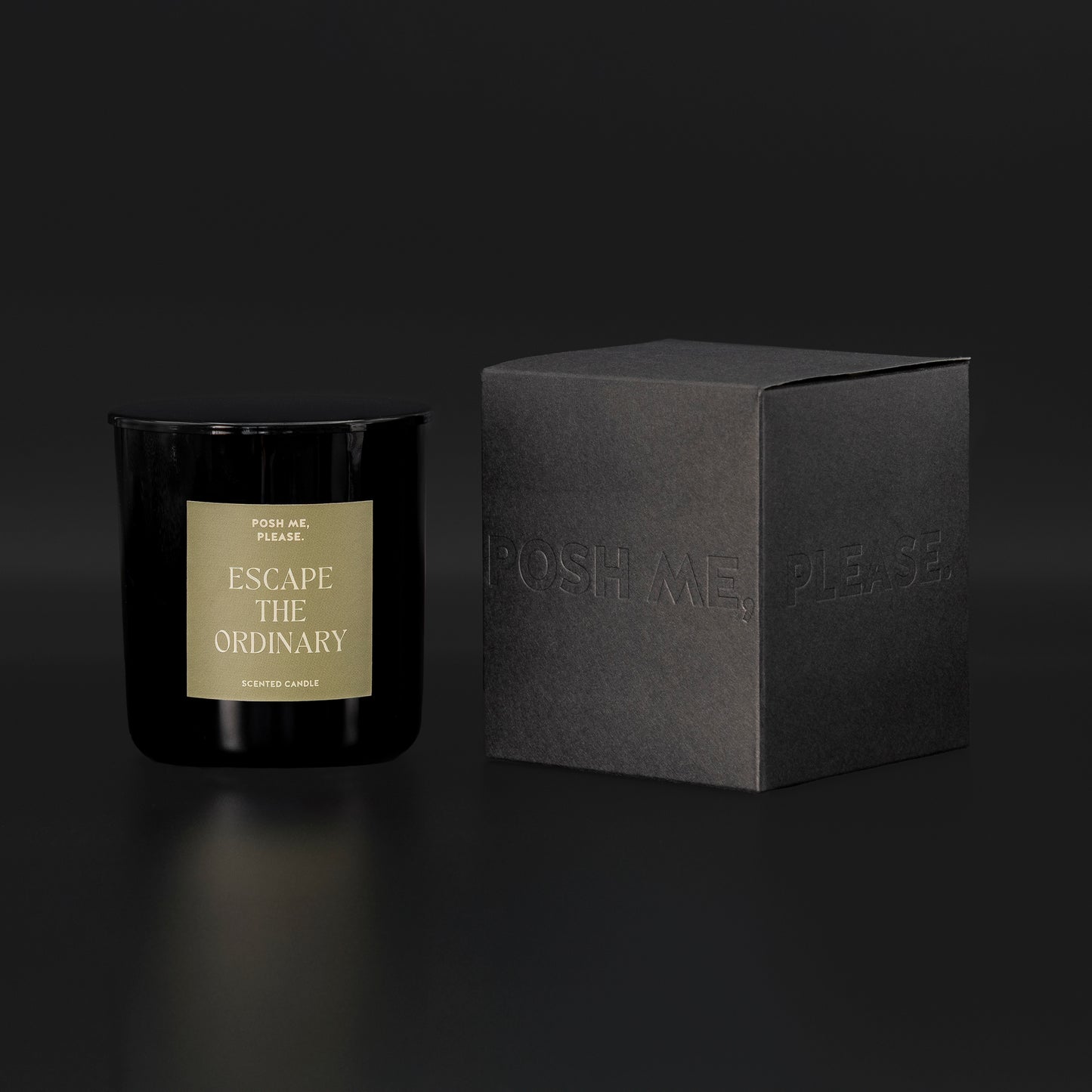 Escape the Ordinary candle beside black embossed POSH ME, PLEASE. gift box, dark background
