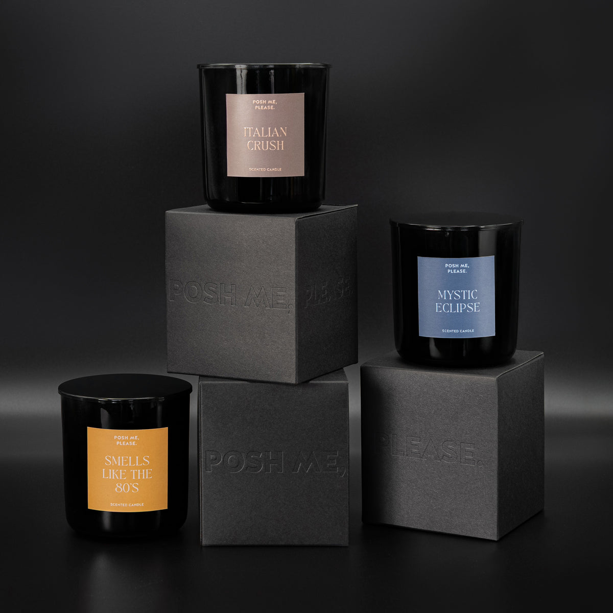 Italian Crush, Mystic Eclipse and Smells Like The 80s candles stacked on embossed POSH ME, PLEASE. black blocks, dark background
