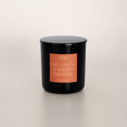 Get Lost in a Golden Paradise black glass candle with copper label by POSH ME, PLEASE., lid on, light background