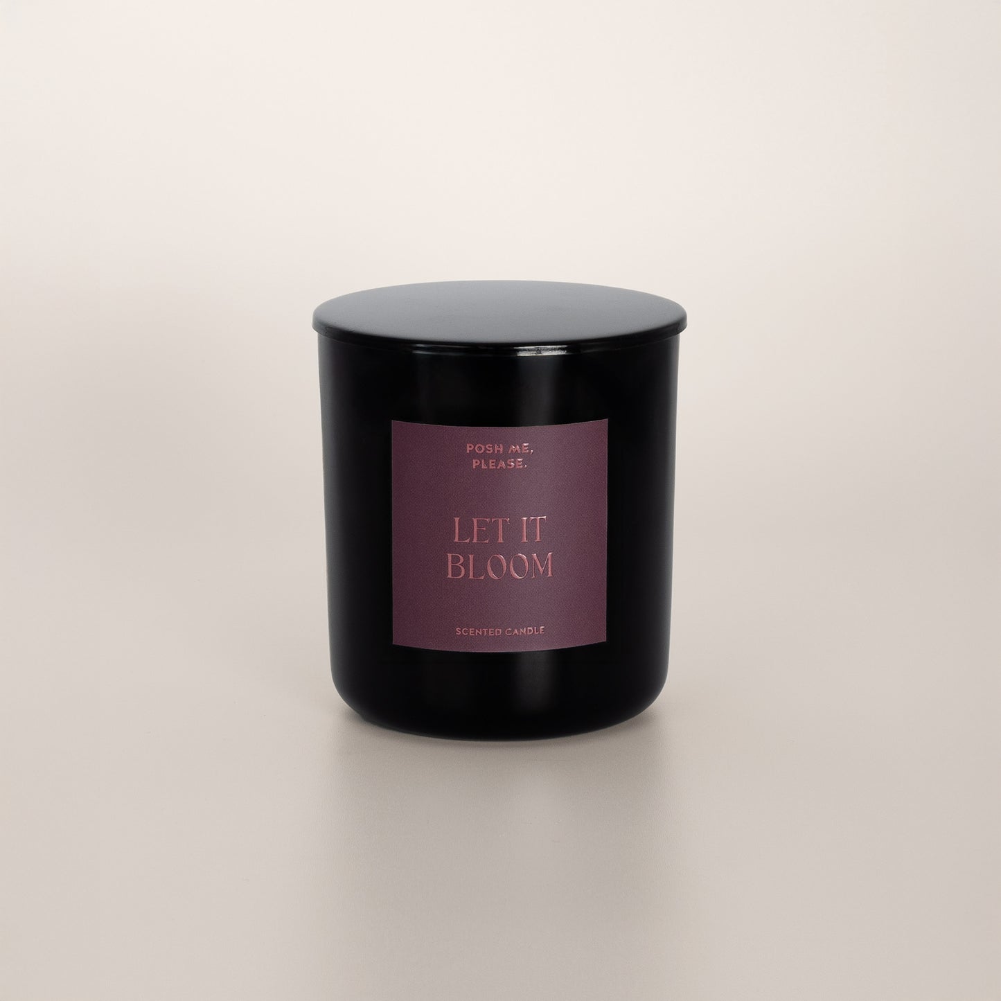 Let It Bloom black glass candle with dusty rose label by POSH ME, PLEASE., lid on, light background