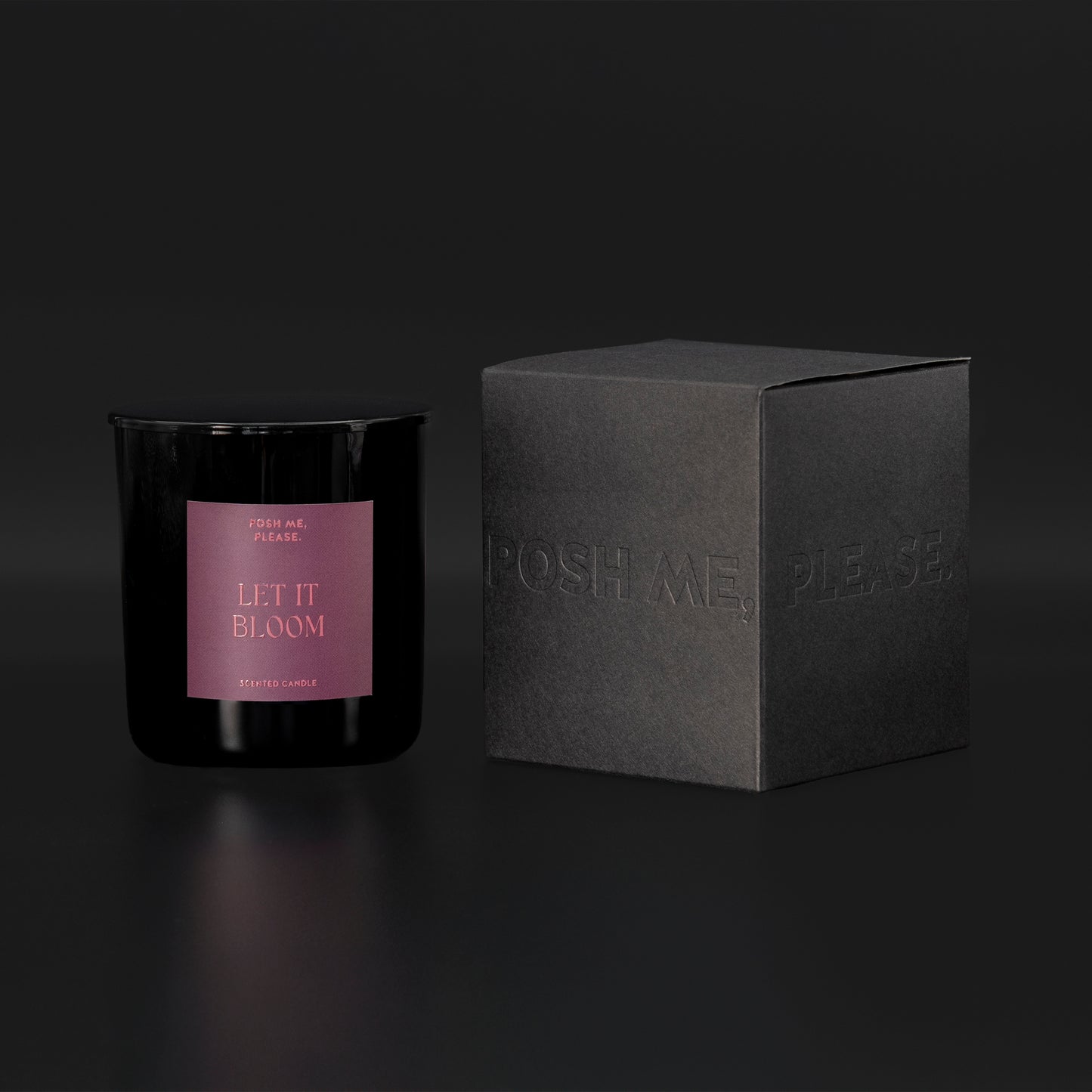 Let It Bloom candle beside black embossed POSH ME, PLEASE. gift box, dark background