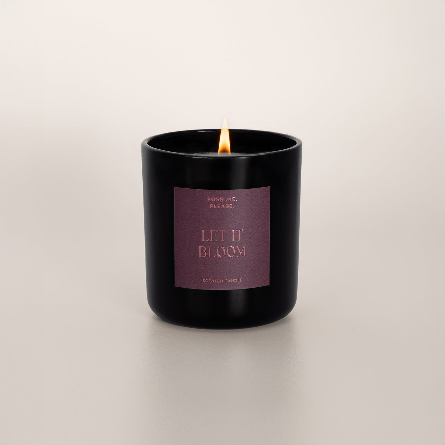 Lit Let It Bloom candle with flame, tuberose jasmine scent, neutral background
