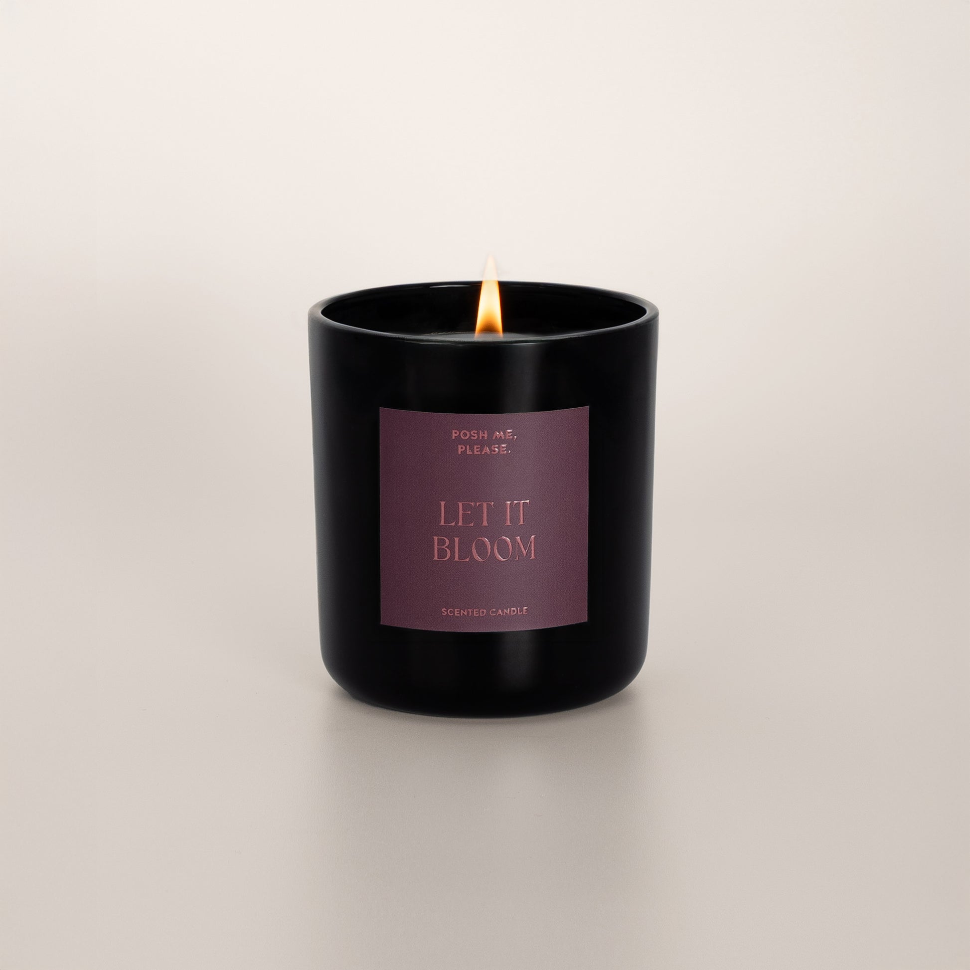 Lit Let It Bloom candle with flame, tuberose jasmine scent, neutral background